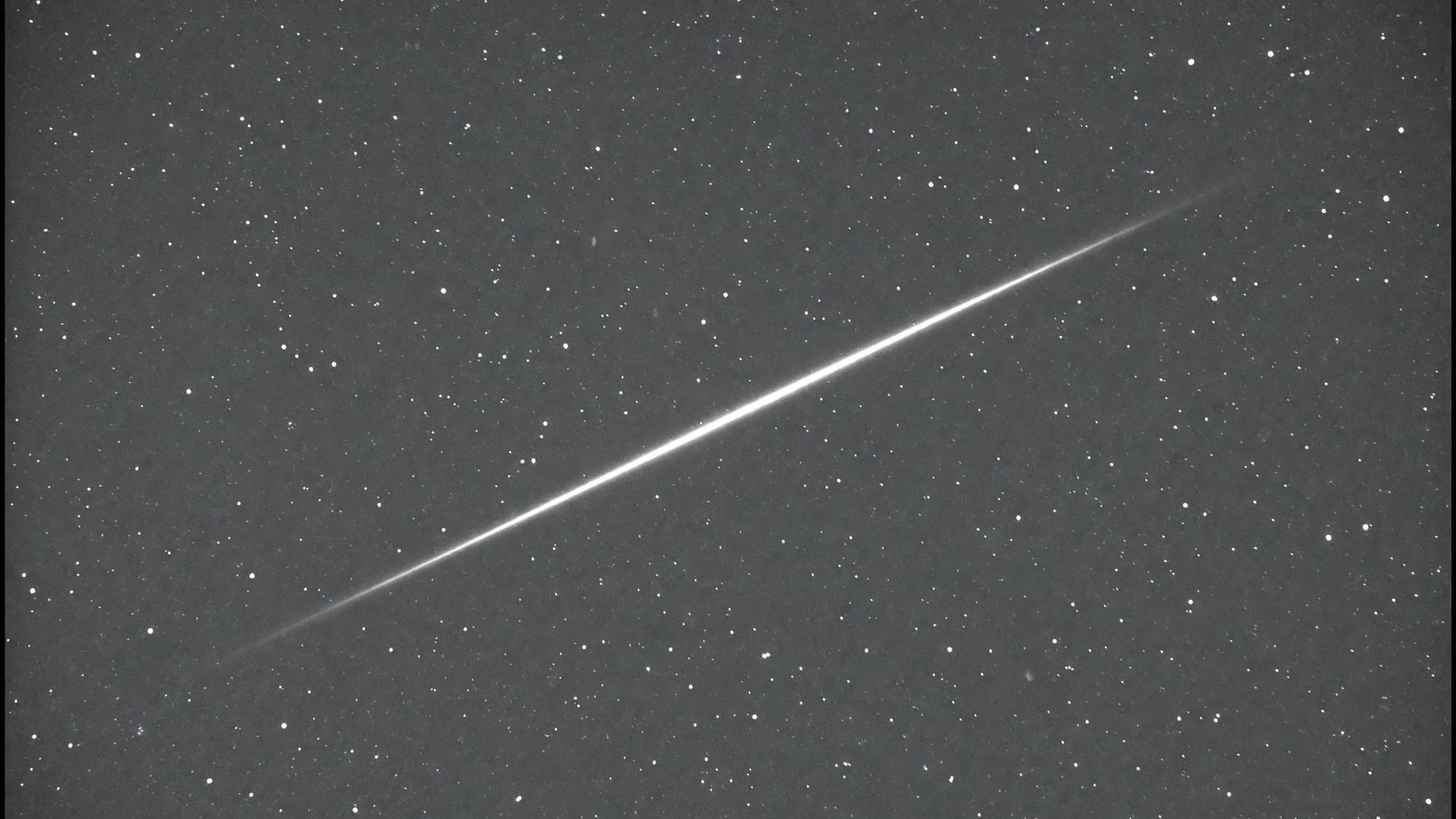 A frame crossed by a bright diagonal satellite streak